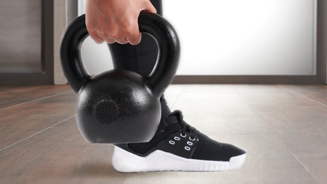 A hand is holding a kettlebell.