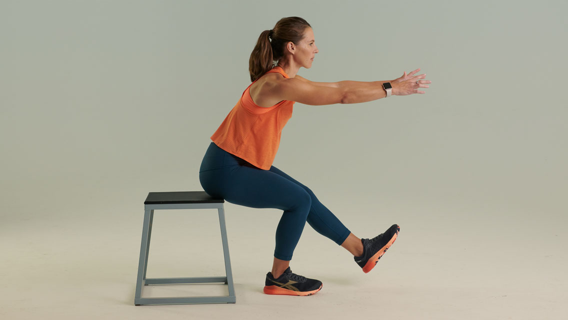 a woman performs a one legged squat on a step