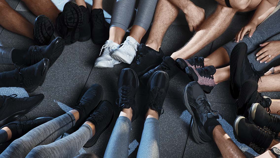 Group of people sitting on floor with legs and feet in a circle.