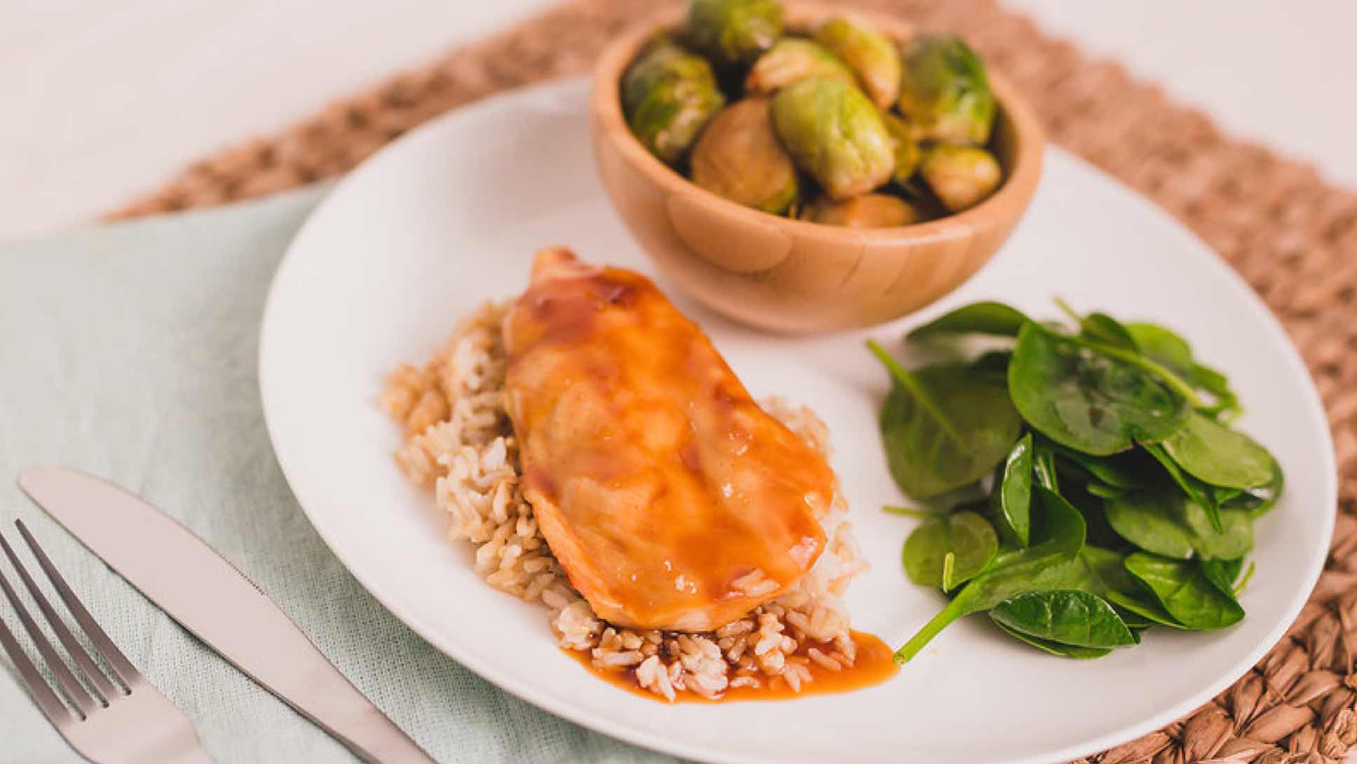 Chicken breast, brown rice, Brussels sprouts and spinach on a plate.