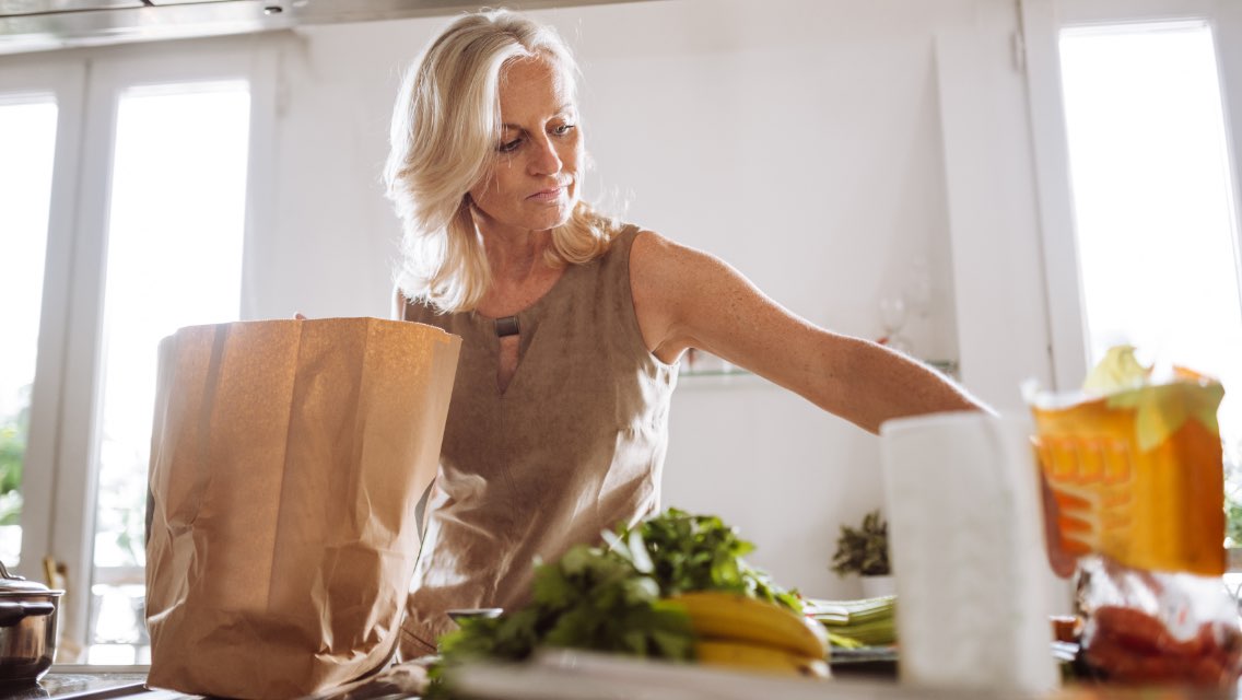 Woman unpacking groceries at home.
