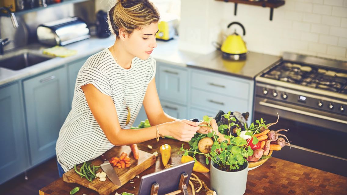 Woman in the kitchen with produce.