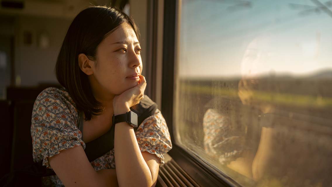 a woman looks out a train window