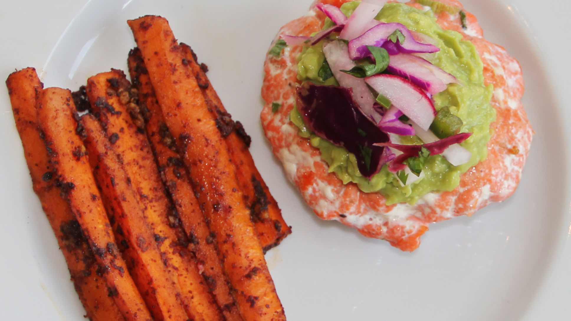 Salmon burger with carrot fries on a plate.