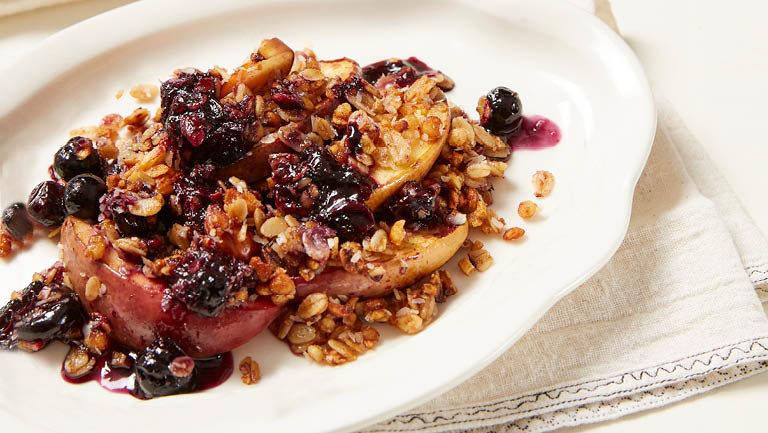 A plate of nectarine and blueberry crisp.