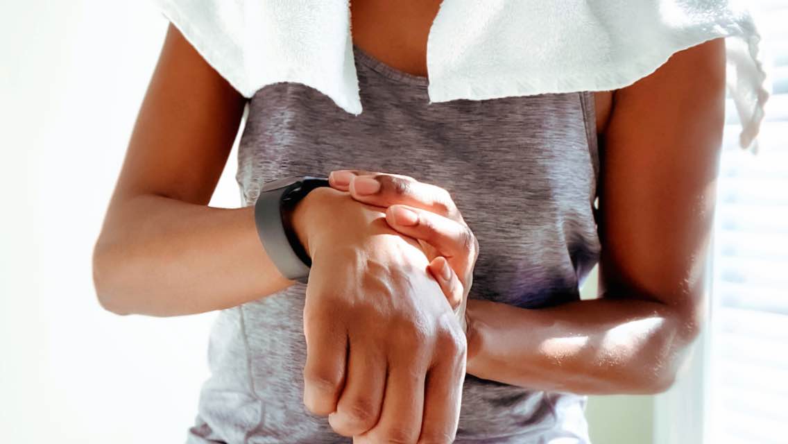 A woman looking at her fitness tracker after exercising.