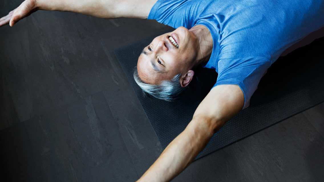 A man laying stretched out on the floor.