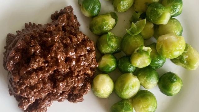 A plate of sloppy joes mix and Brussels sprouts.