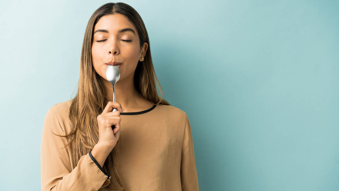 a woman licks the end of a spoon