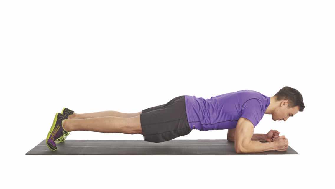 A man doing a plank on a yoga mat.