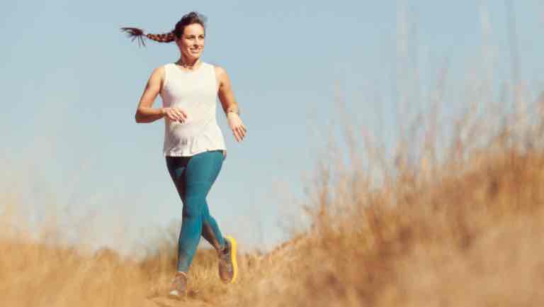 Gigi Skeehan running by herself outside in a field.