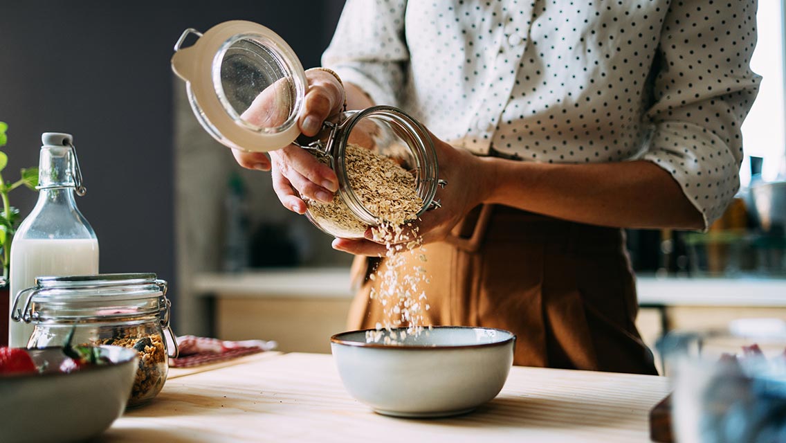 Woman pouring oats into a bowl