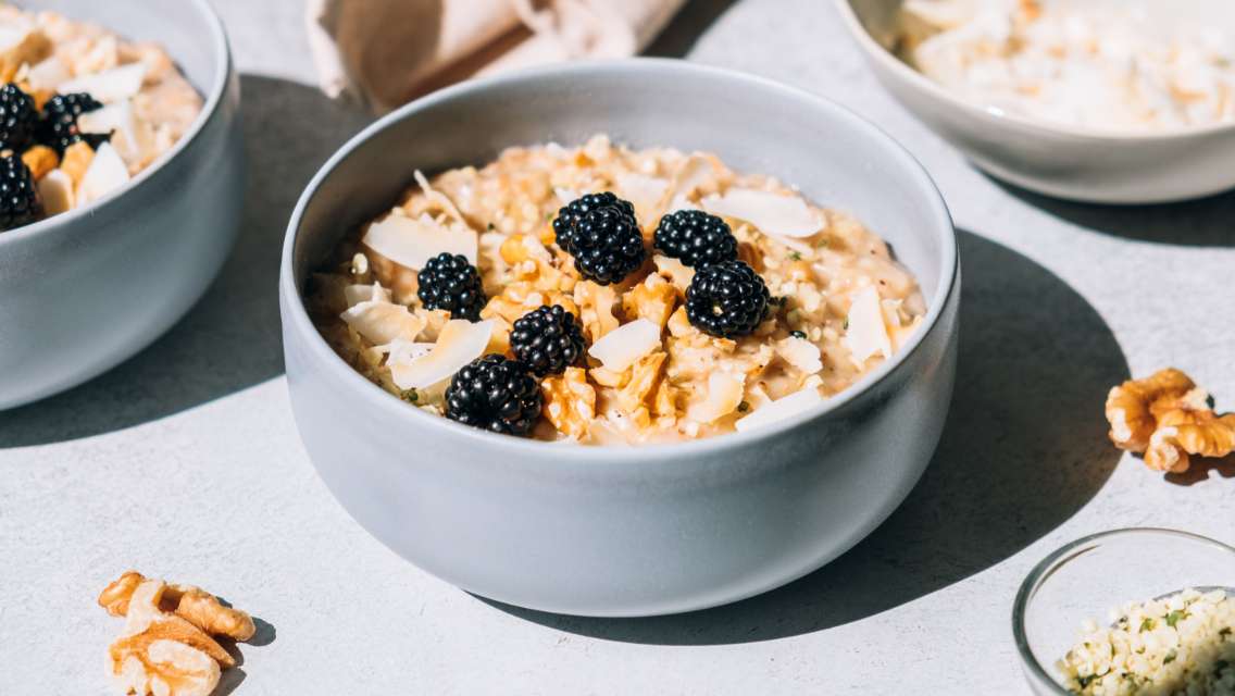 A bowl of oatmeal topped with blackberries and slivered almonds.