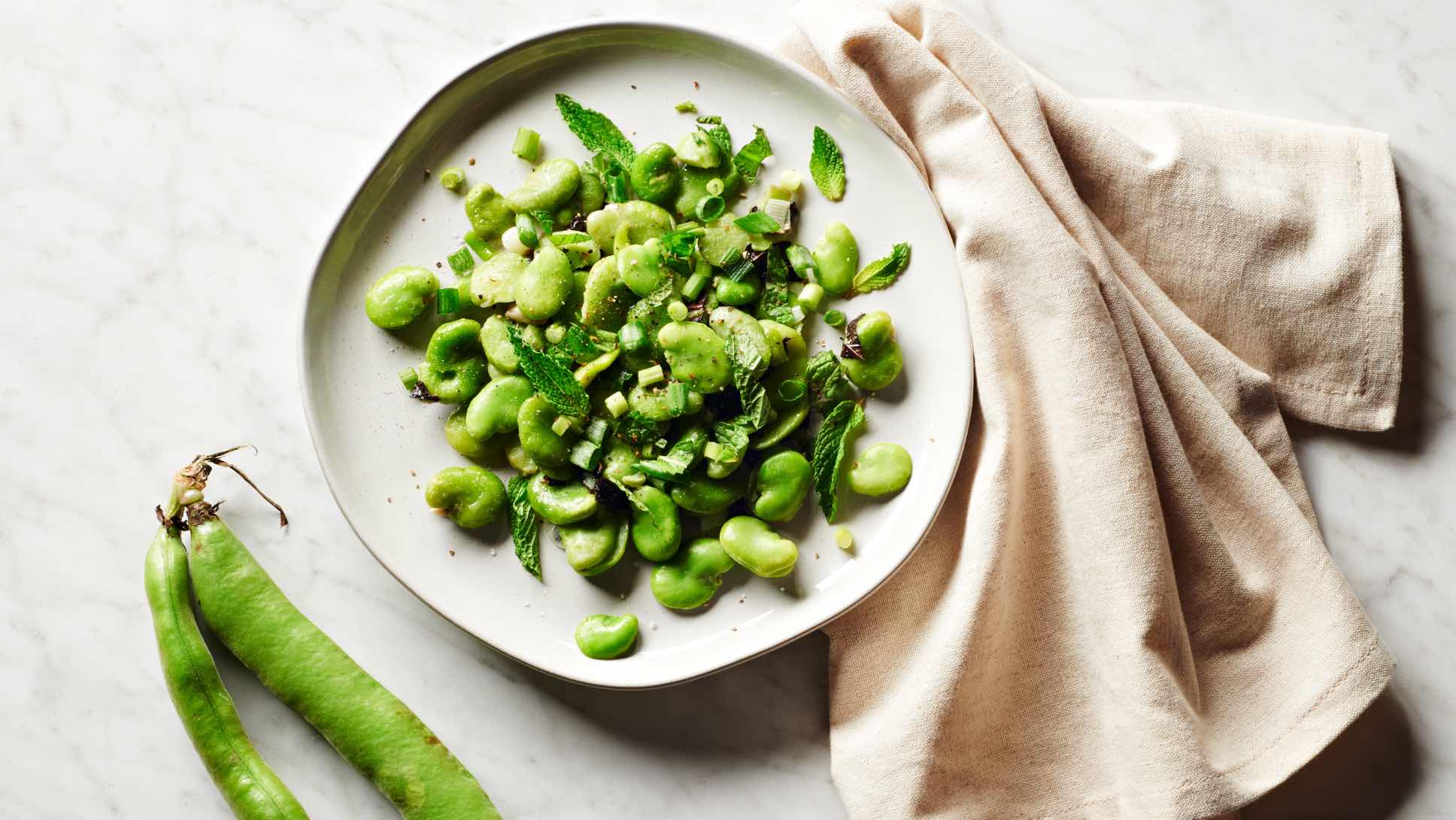 A plate of fresh fava beans with mint and scallions.
