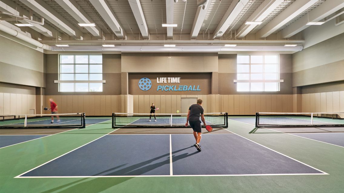Two people playing pickleball on a court at Life Time