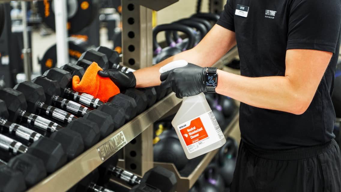 life time employee cleaning rack of dumbbells
