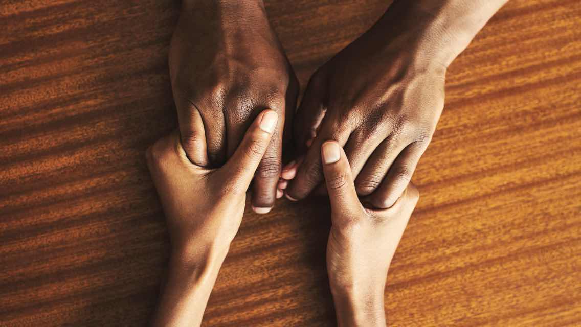 two pairs of hands holding
