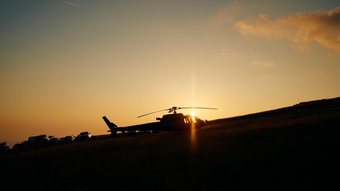 A helicopter landed during a sunset.