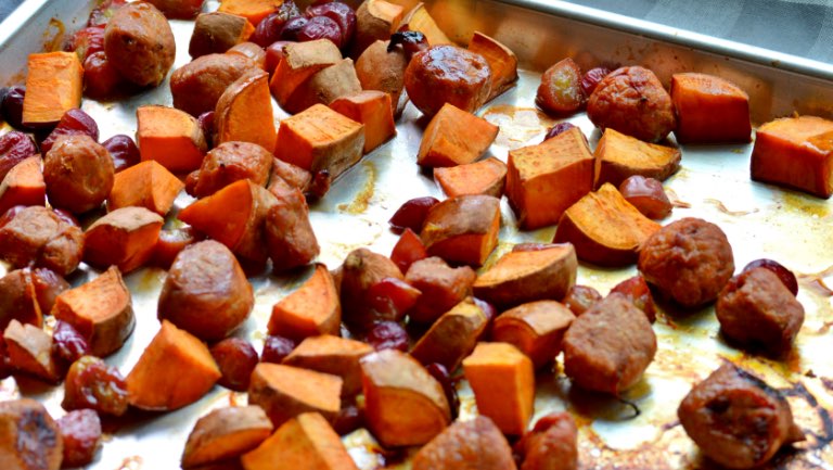 Sheet pan of oven-roasted sausage, sweet potatoes, and grapes.