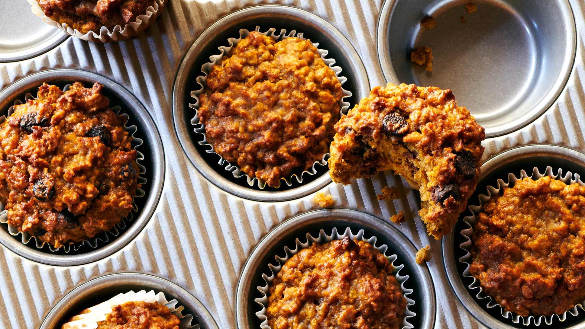 Pumpkin muffins inside a muffin tin.