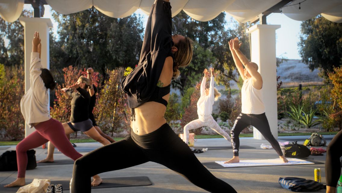 A group of people doing yoga outside.