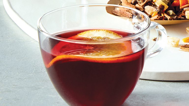 A glass of mulled cider with hibiscus.