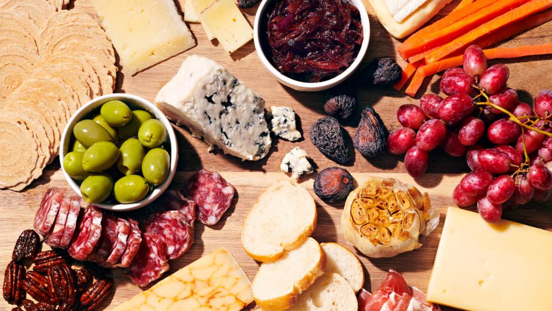 A charcuterie board spread of foods.