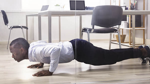 man doing push ups in office