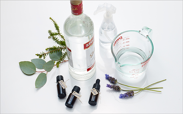 a bottle of vodka, pyrex with water, spray bottle and botanicals