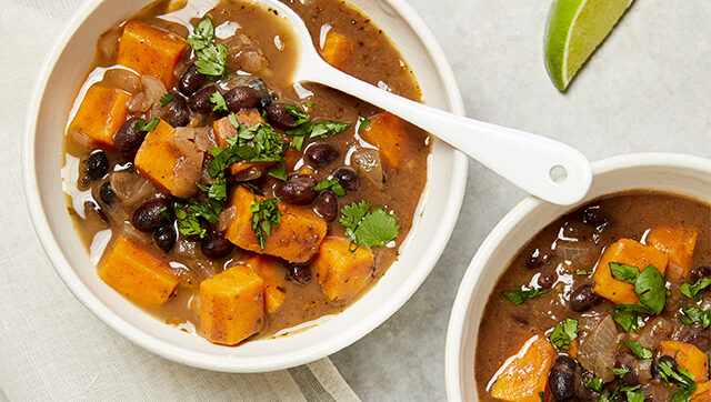 Two bowls of soup with black beans and sweet potatoes