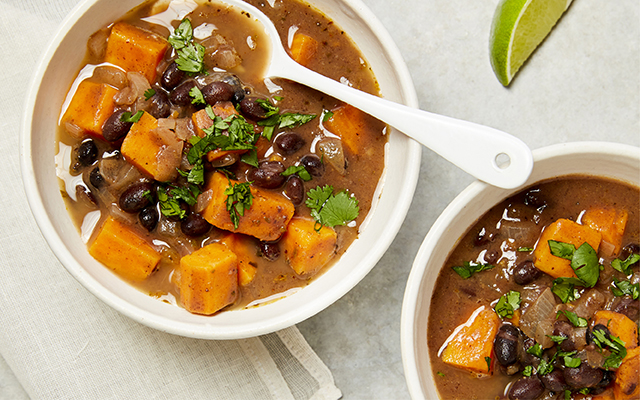 Two bowls of soup with black beans and sweet potatoes
