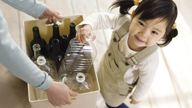 child putting recyclables in a box