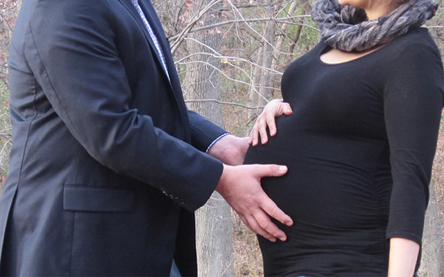 husband touching wife's pregnant belly