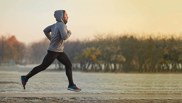 A person jogs at sunset.