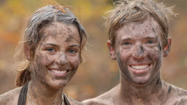 man and woman covered in mud