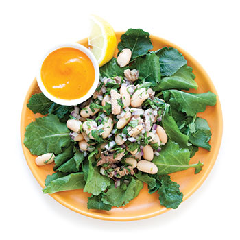 Sardine and white bean salad on an orange plate