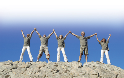 people with arms up on hill