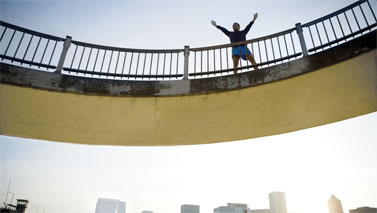 person with arms up on bridge