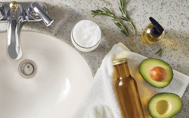 Oil cleanser, moisturizer, and avocados next to sink