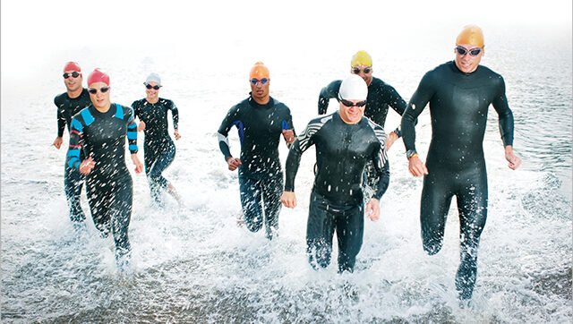 Group of people running out of the water during a race