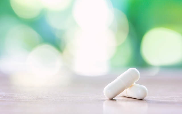 Two probiotic supplements with green background