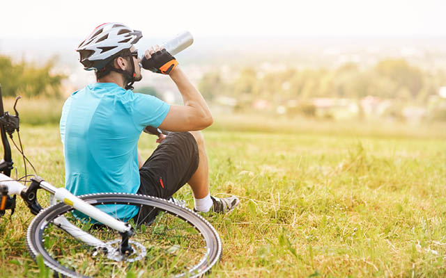 Cyclist resting and drinking water