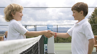 kids shaking hands over tennis net