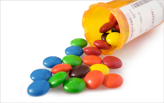 An image of a pill bottle filled with colored candies