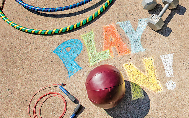 A colorful sign saying "Play On!" with balls, hula hoops, and other toys around it