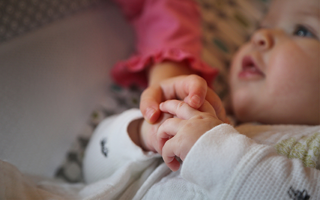 toddler and baby holding hands