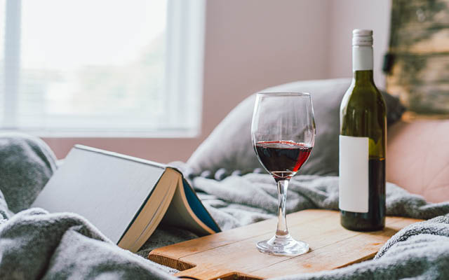 a glass of wine sitting along side a book