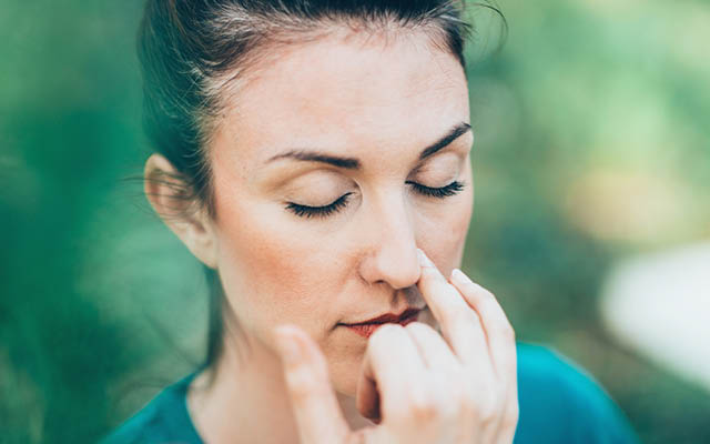 a woman practicing alternate nostril breathing