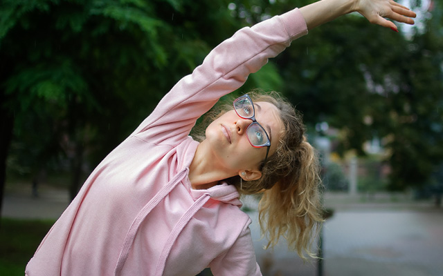 Athletic woman with eye glasses stretching