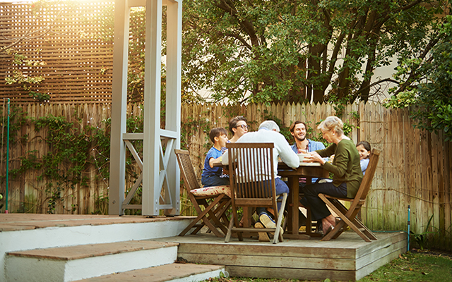 A happy family enjoys lunch together outside.